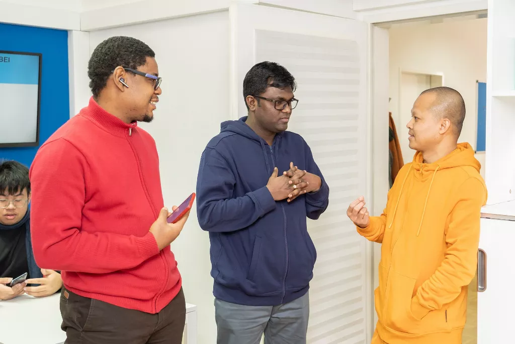 Eine Gruppe von drei Männern, die nebeneinander stehen