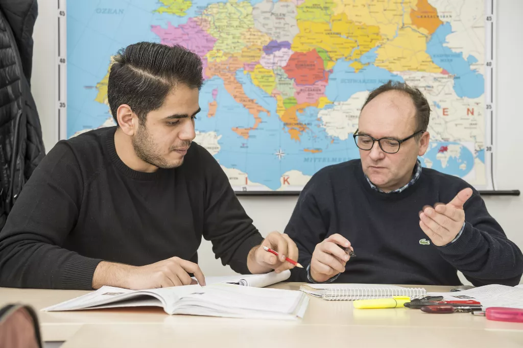 Mitarbeiter in einem Deutschkurs gibt Tipps