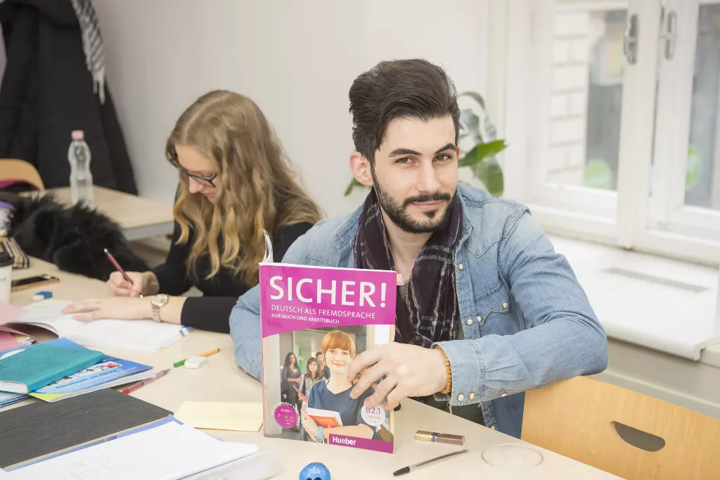 Ein Mann sitzt mit einem Buch an einem Tisch