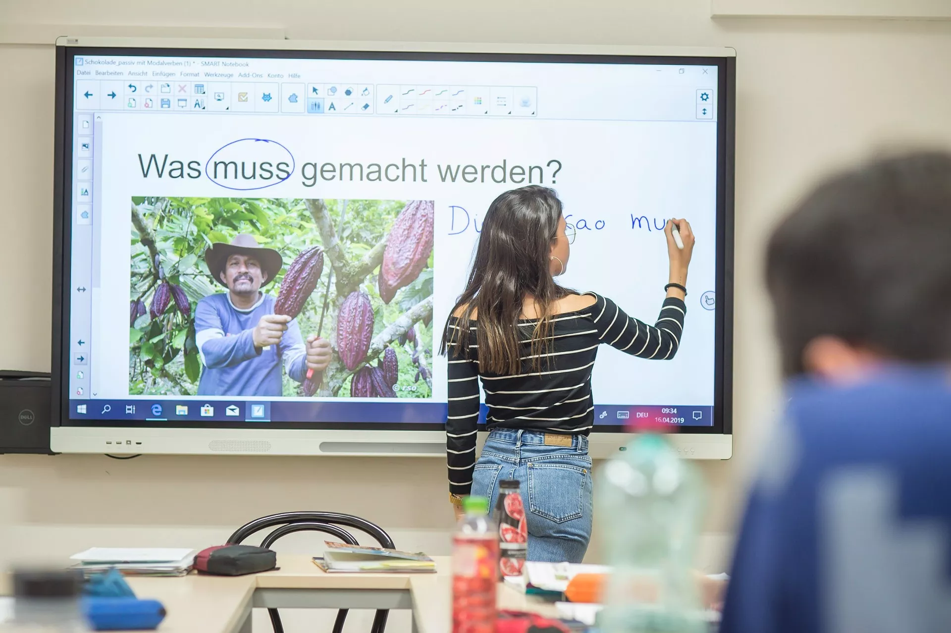 Eine Frau steht vor einem großen Bildschirm