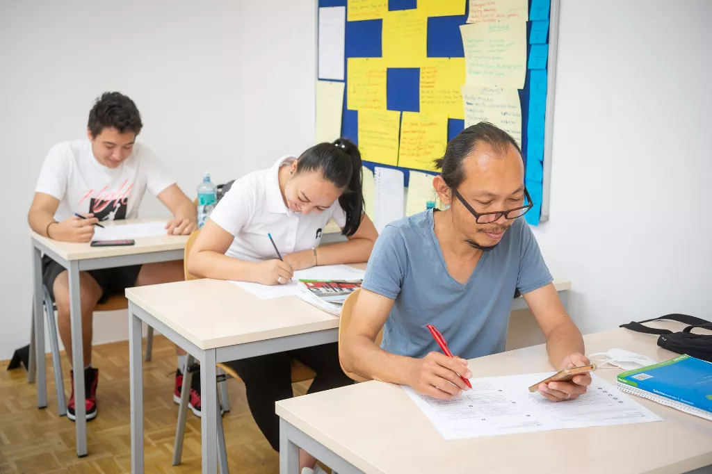 Teilnehmer die gerade in einem deutschkurs etwas ausarbeiten