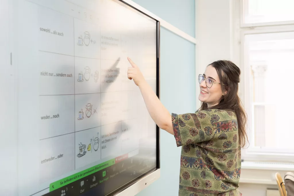 Eine Mitarbeiterin die auf einem Display etwas zeigt