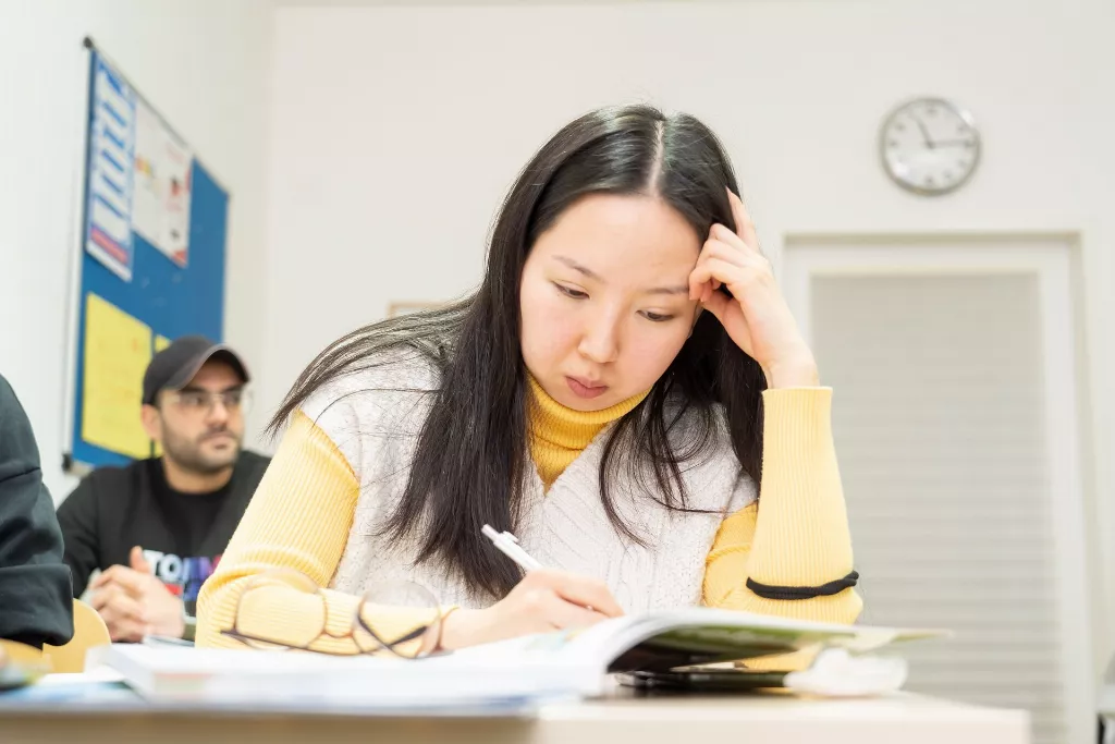 Eine Kursteilnehmerin die ihre Prüfungen schreibt