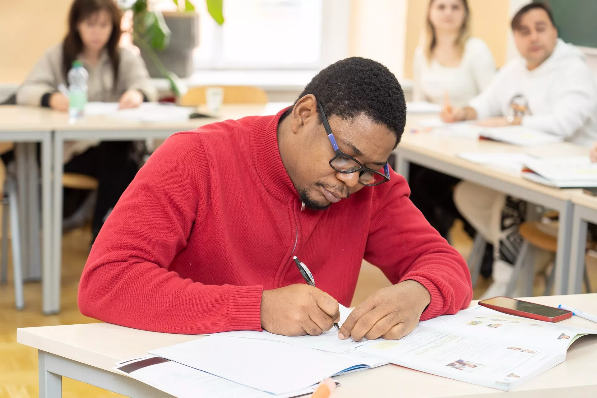 Ein Teilnehmer der gerade den schriftlichen Tein seiner ÖIF Prüfung schreibt