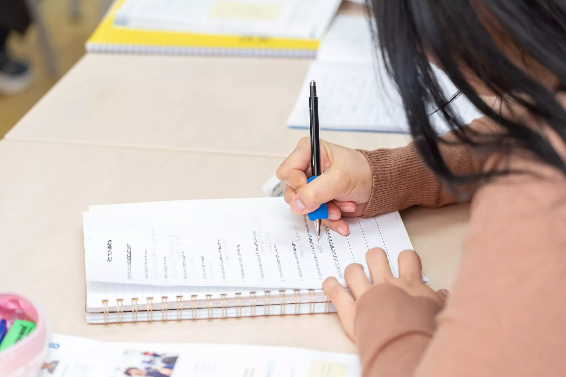 Eine Teilnehmerin schreibt bei einem Deutschkurs mit