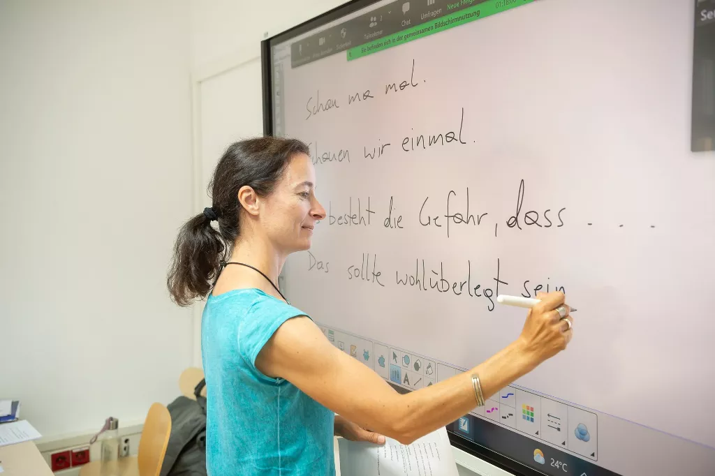Text & Grammatik Kurs Deutsch: Mitarbeiterin arbeitet Texte auf einen Monitor aus