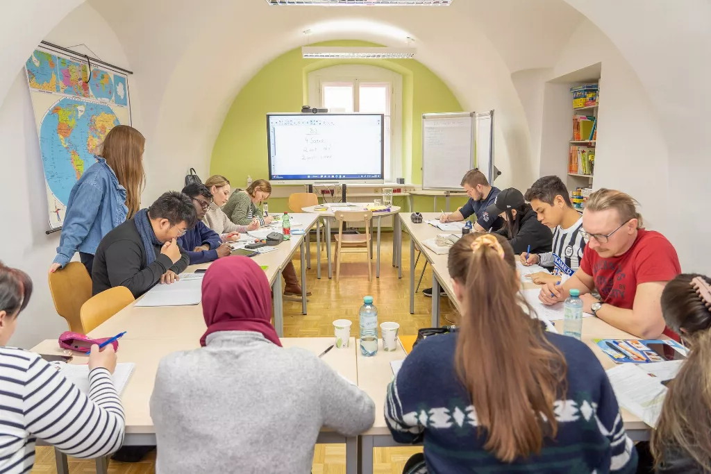 Eine Gruppe von Menschen sitzt an Tischen in einem Raum